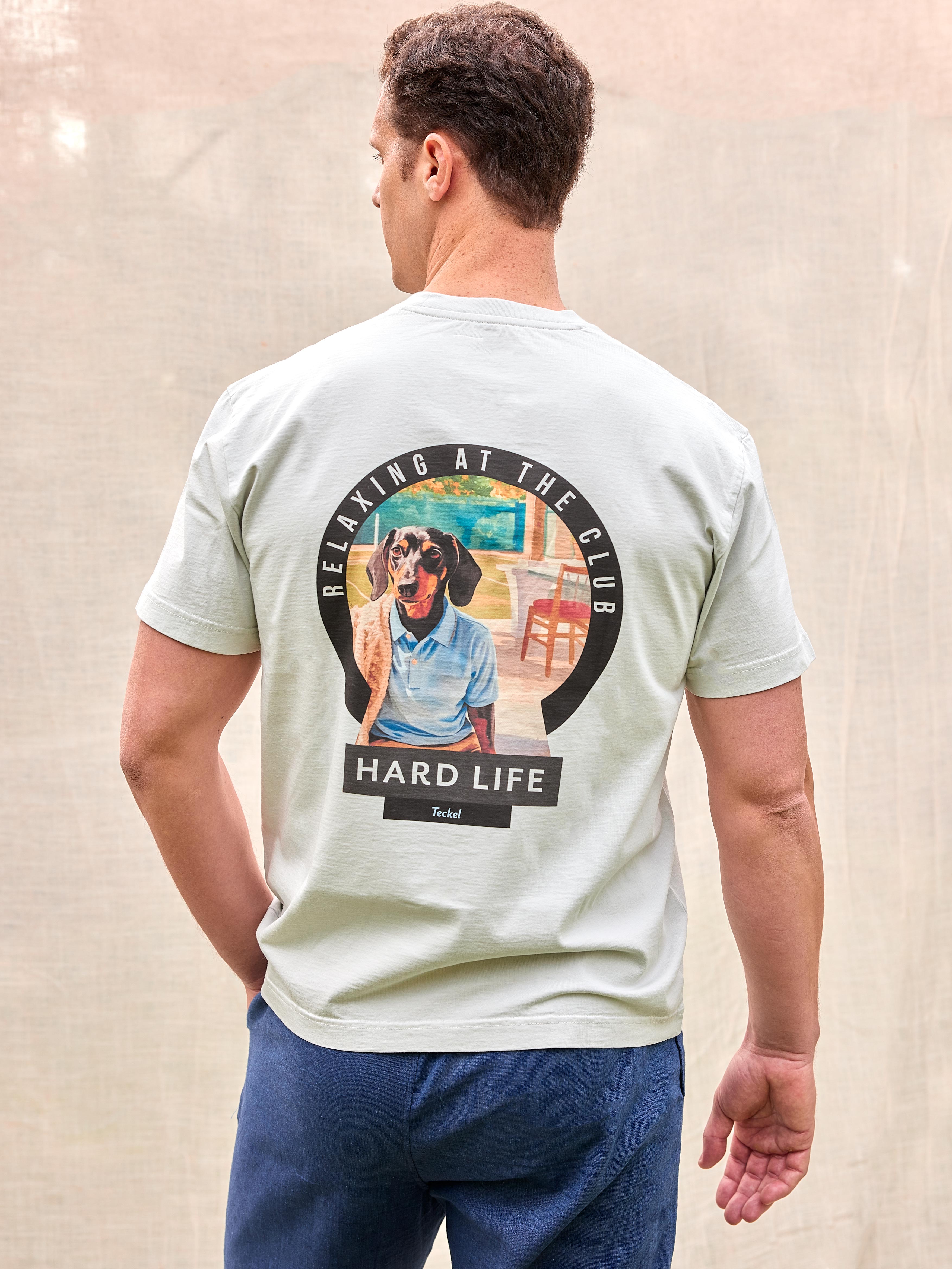 Camiseta premium exclusiva hombre perro raza Teckel perro salchicha dachshund dackel 100% algodón orgánico gramaje alto 200 gramos heavy weight hecha en Portugal color azul grisáceo verde gris impresión diseño directo en fibra alta calidad premium moda masculina España Arzalè Majadahonda Pozuelo La Moraleja La Finca Encinar de Los Reyes Sancti Petri Formentera Sevilla Ibiza Madrid Barcelona